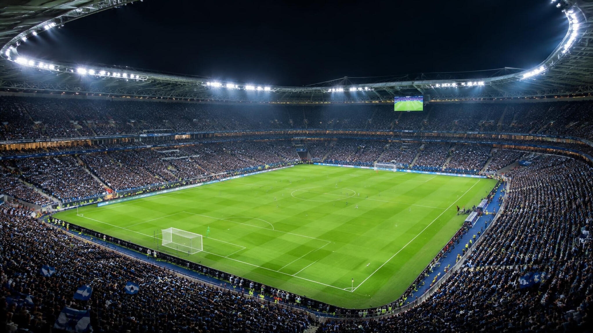 Football stadium under floodlights at night