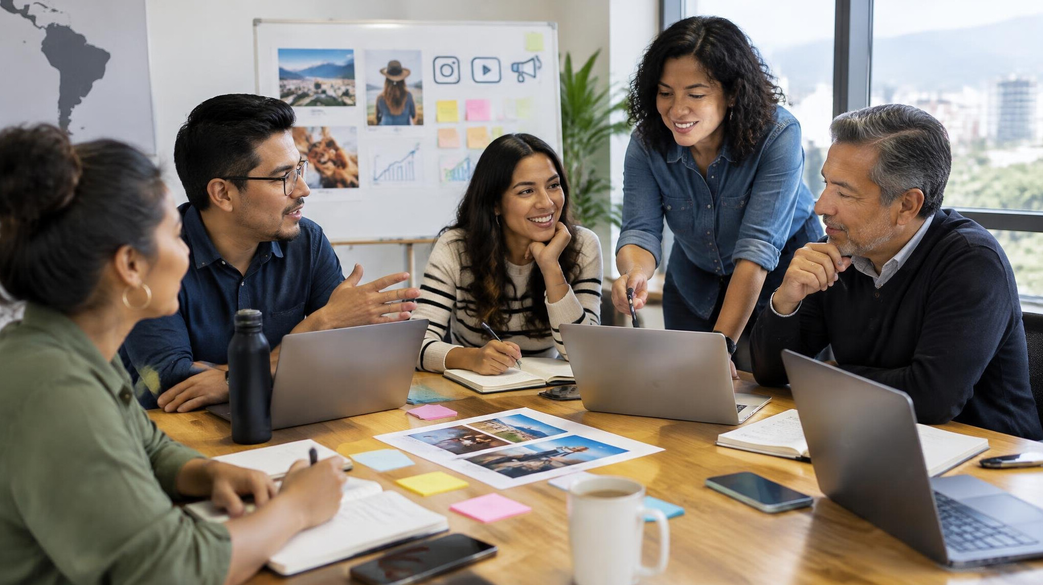 Marketing team meeting around a table with laptops